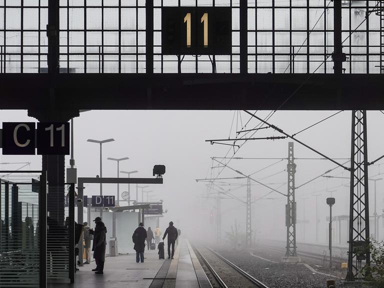 Reisende warten im Nebel auf dem Leipziger Hauptbahnhof.