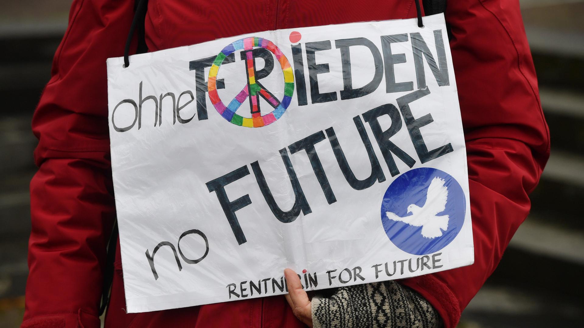 Nordrhein-Westfalen, Dortmund: "ohne Frieden no Future - Rentnerin for future" steht auf einem Plakat, das eine Frau am Ostermontag zum Abschluss des Ostermarsch Rhein-Ruhr 2021 zeigt.