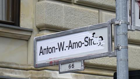 Strassenschild der Anton-Wilhelm-Amo-Straße, daneben ein Strassenschild, was nicht zu erkennen ist weil es besprüht ist