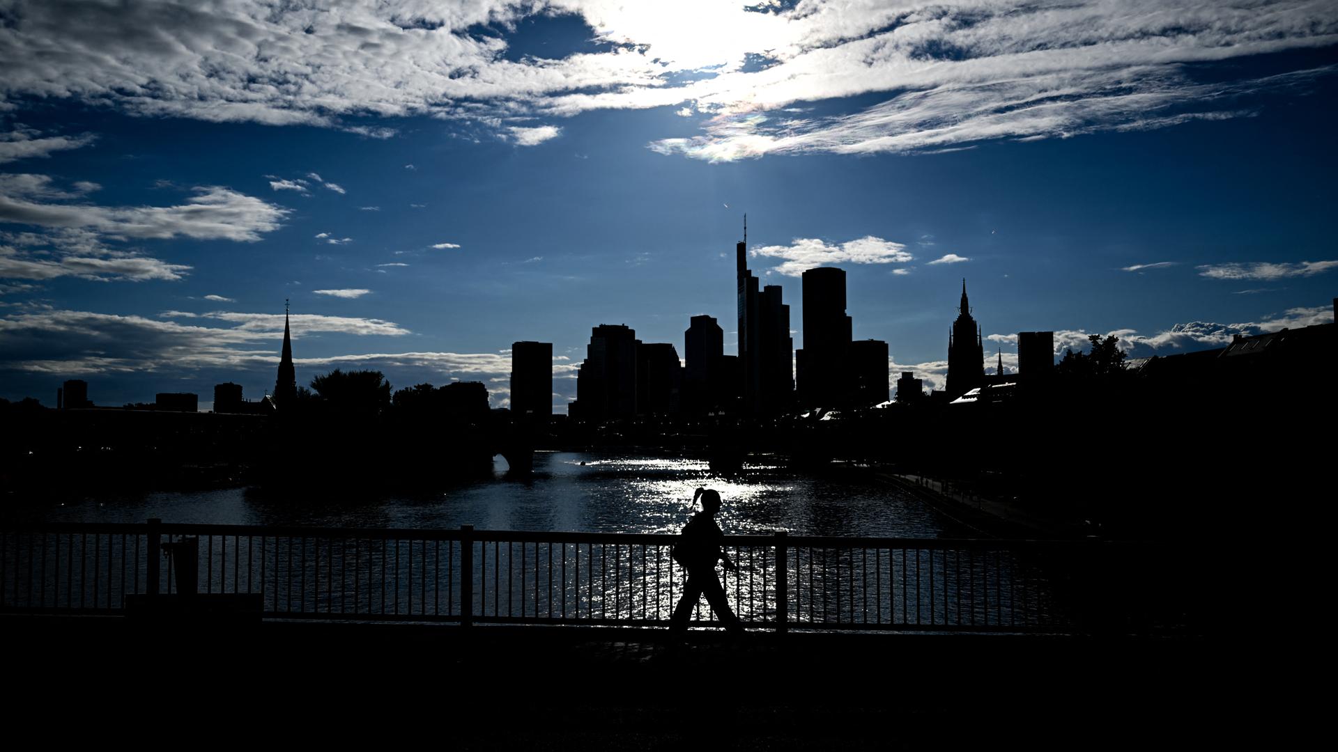 Vor einem hellen Sommerhimmel heben sich als dunkle Silhouetten die Hochhäuser des Frankfurter Bankenviertel ab. Vor einem hellen Sommerhimmel heben sich als dunkle Silhouetten die Hochhäuser des Frankfurter Bankenviertel ab.