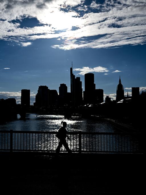 Vor einem hellen Sommerhimmel heben sich als dunkle Silhouetten die Hochhäuser des Frankfurter Bankenviertel ab. Vor einem hellen Sommerhimmel heben sich als dunkle Silhouetten die Hochhäuser des Frankfurter Bankenviertel ab.