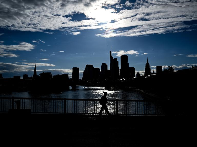 Vor einem hellen Sommerhimmel heben sich als dunkle Silhouetten die Hochhäuser des Frankfurter Bankenviertel ab. Vor einem hellen Sommerhimmel heben sich als dunkle Silhouetten die Hochhäuser des Frankfurter Bankenviertel ab.