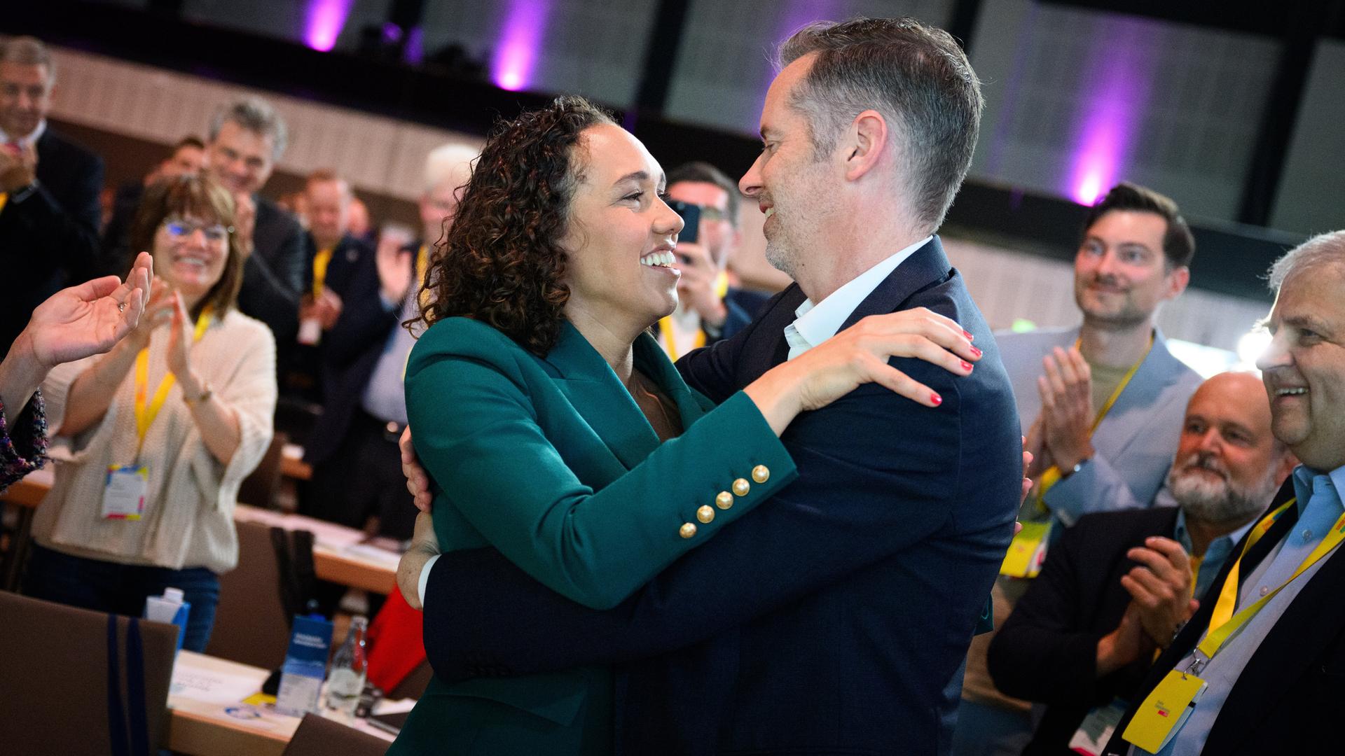 Nicole Büttner und Christian Dürr umarmen sich lächelnd. Dahinter weitere aplaudierende Delegierte. Nicole Büttner und Christian Dürr umarmen sich lächelnd. Dahinter weitere aplaudierende Delegierte.