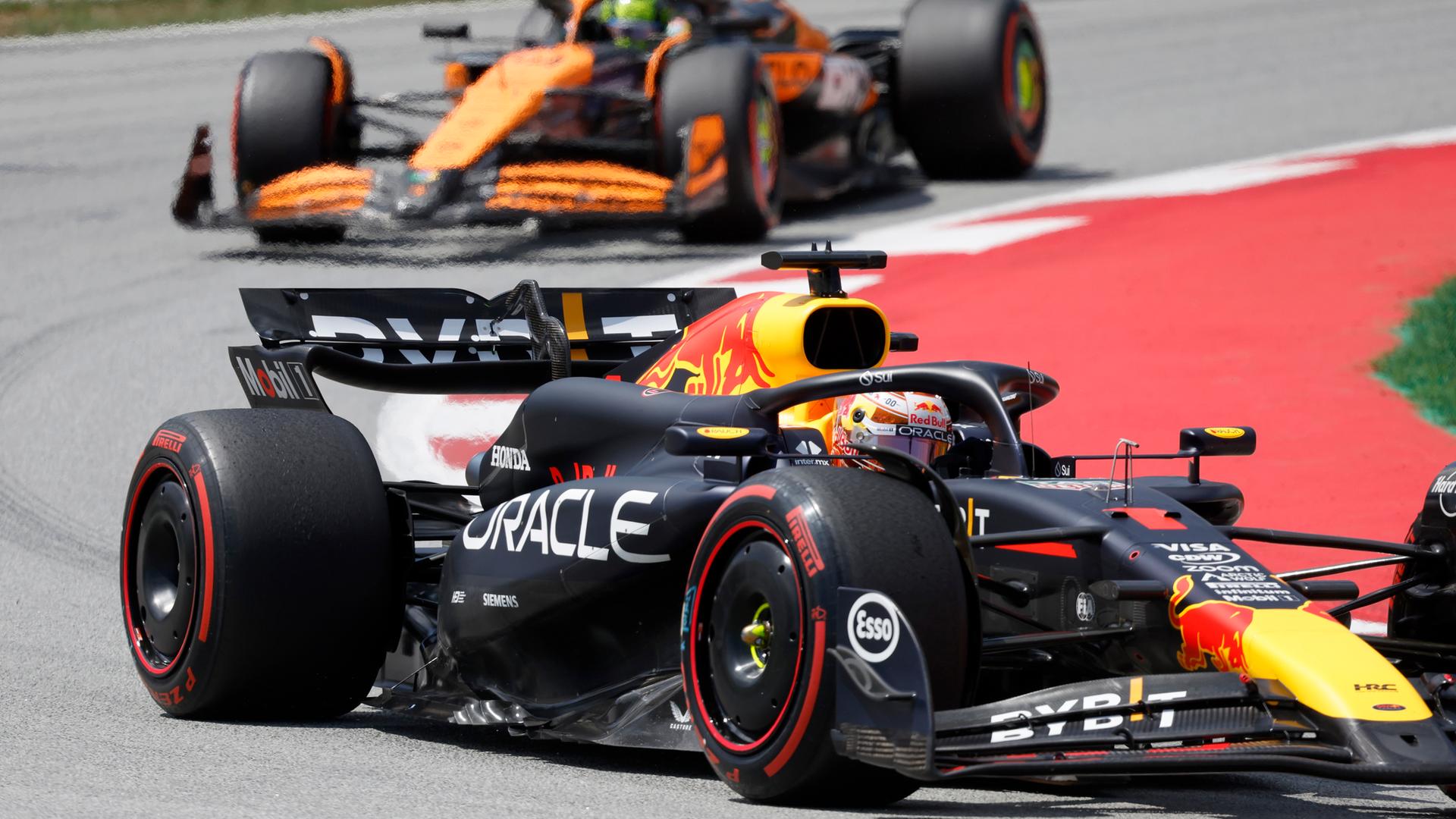 Eine Nahaufnahme zweier Formel-1-Autos in einer Kurve. Eine Nahaufnahme zweier Formel-1-Autos in einer Kurve.