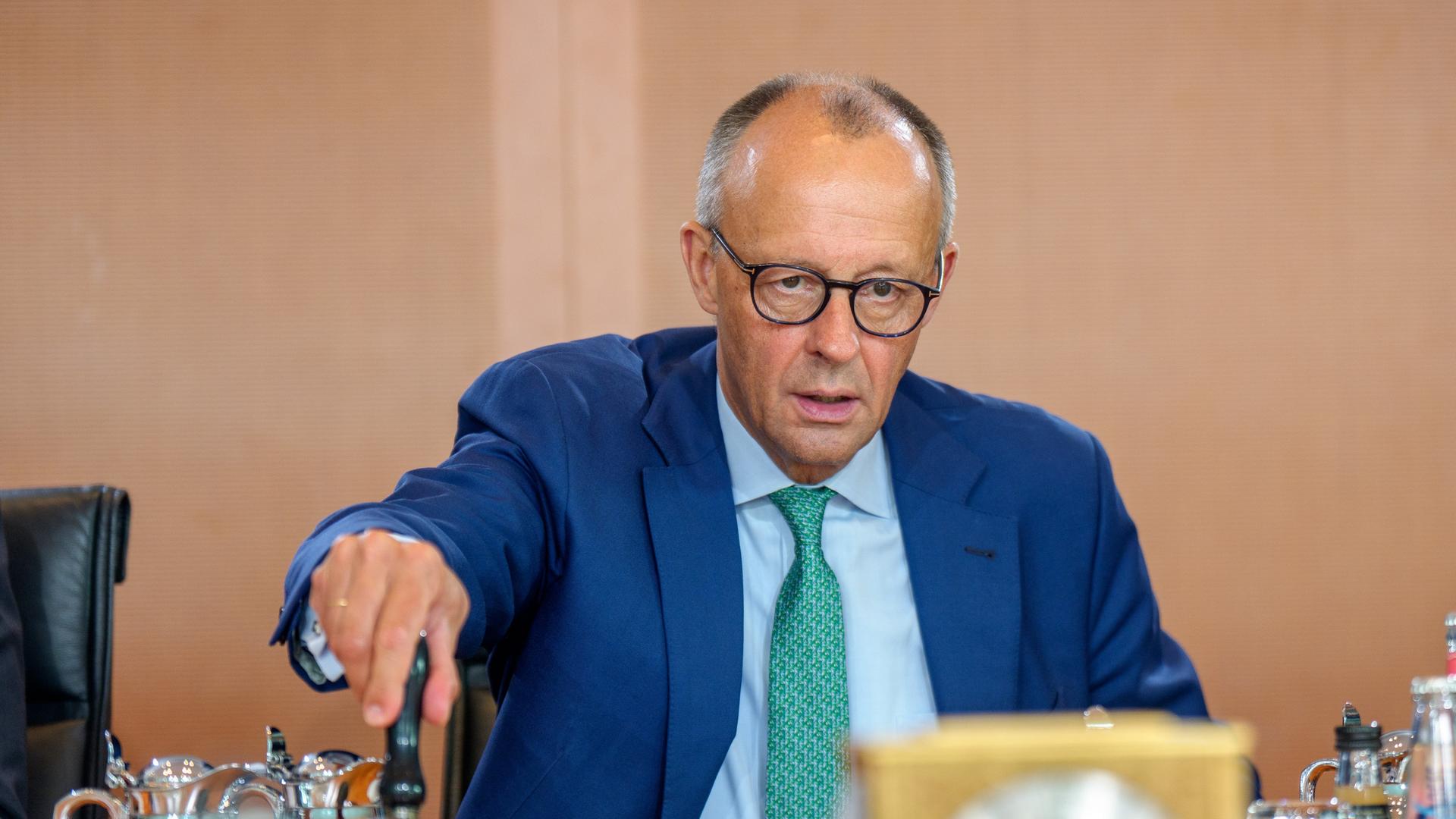 Bundeskanzler Friedrich Merz (CDU) läutet die Glocke zu Beginn der Sitzung des Bundeskabinetts im Kanzleramt. 