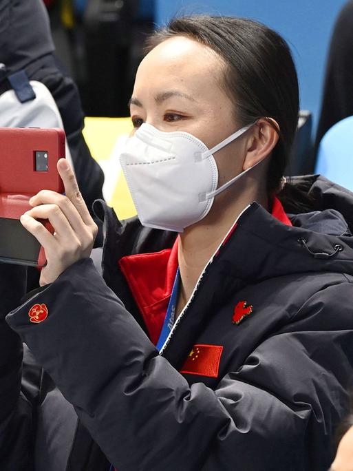 Peng Shuai fotografiert bei einem olympischen Eiskunstlauf-Wettkampf in Peking mit ihrer Handykamera. 