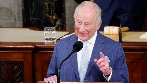 König Charles steht am Redepult im US-Kongress in Washington und spricht in ein Mikrofon. Er schmunzelt dabei.