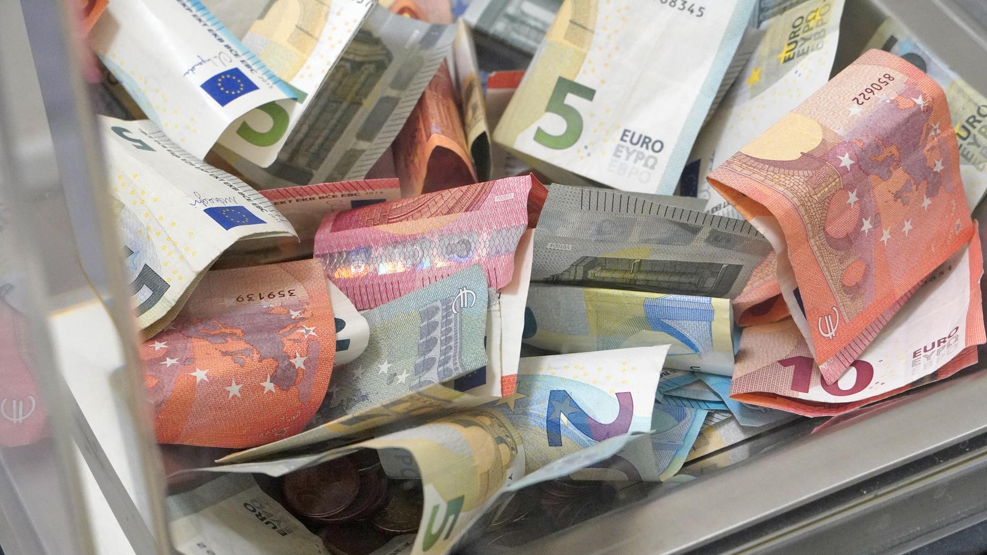 Gläserne Spendenbox mit Euro-Scheinen Gläserne Spendenbox mit Euro-Scheinen