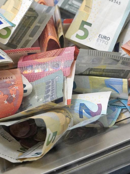 Gläserne Spendenbox mit Euro-Scheinen