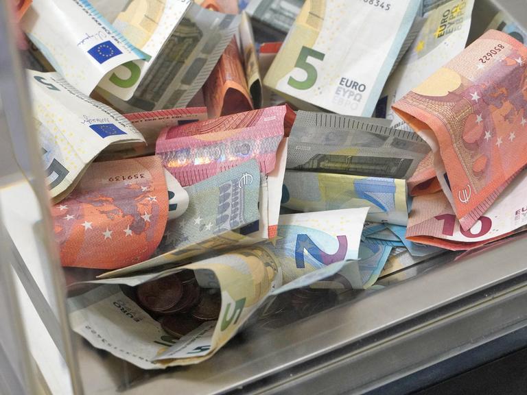 Gläserne Spendenbox mit Euro-Scheinen