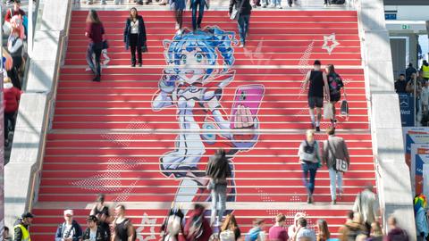 Eine rote Treppe mit einer Manga-Zeichnung und Menschen