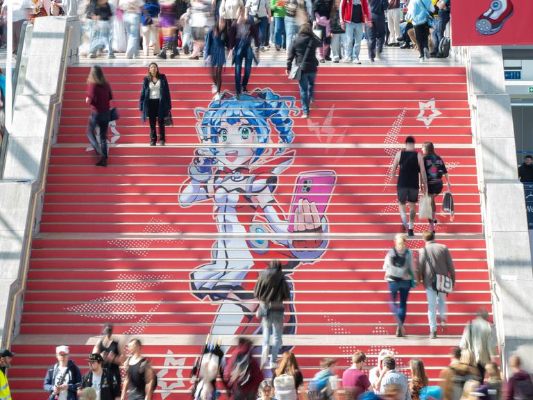 Eine rote Treppe mit einer Manga-Zeichnung und Menschen