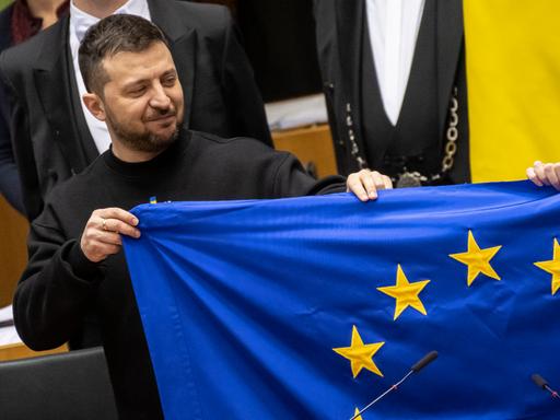 Der ukrainische Präsident Wolodymir Selenskyj hält eine EU-Flagge hoch