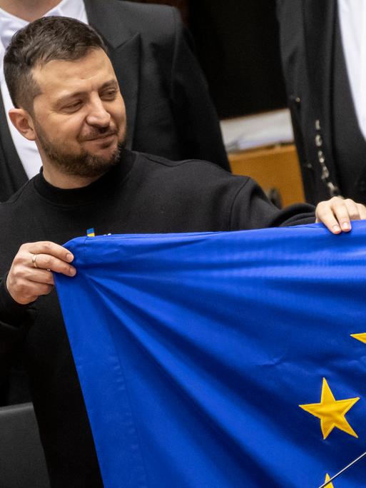 Der ukrainische Präsident Wolodymir Selenskyj hält eine EU-Flagge hoch