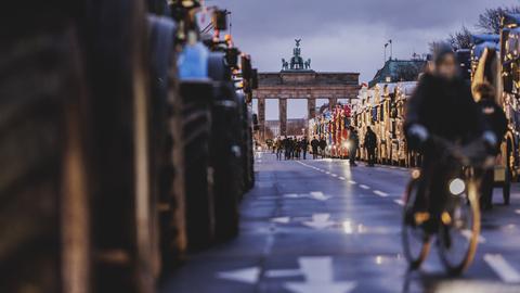 Traktoren und LKWs blockieren die Straße des 17. Juni, im Hintergrund ist das Brandenburger Tor zu sehen.