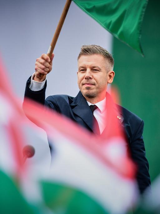 Der ungarische Ministerpräsident Péter Magyar schwenkt die ungarische Flagge während der Feierlichkeiten zum 70. Jahrestag der ungarischen Revolution von 1956 am 23. Oktober 2026.