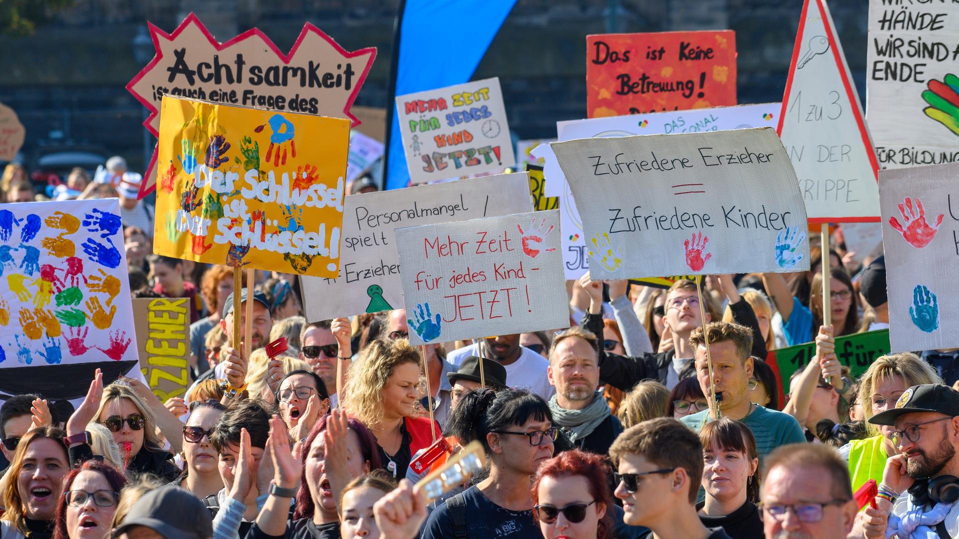 Teilnehmer eines Aktionstages von Kindertagesstätten und Horten demonstrieren vor vor dem Landtag von Sachsen-Anhalt unzählige Schilder in den Höhe auf denen unter anderem "Mehr Zeit für jedes Kind" und "Der Schlüssel ist der Schlüssel!" zu lesen ist. 