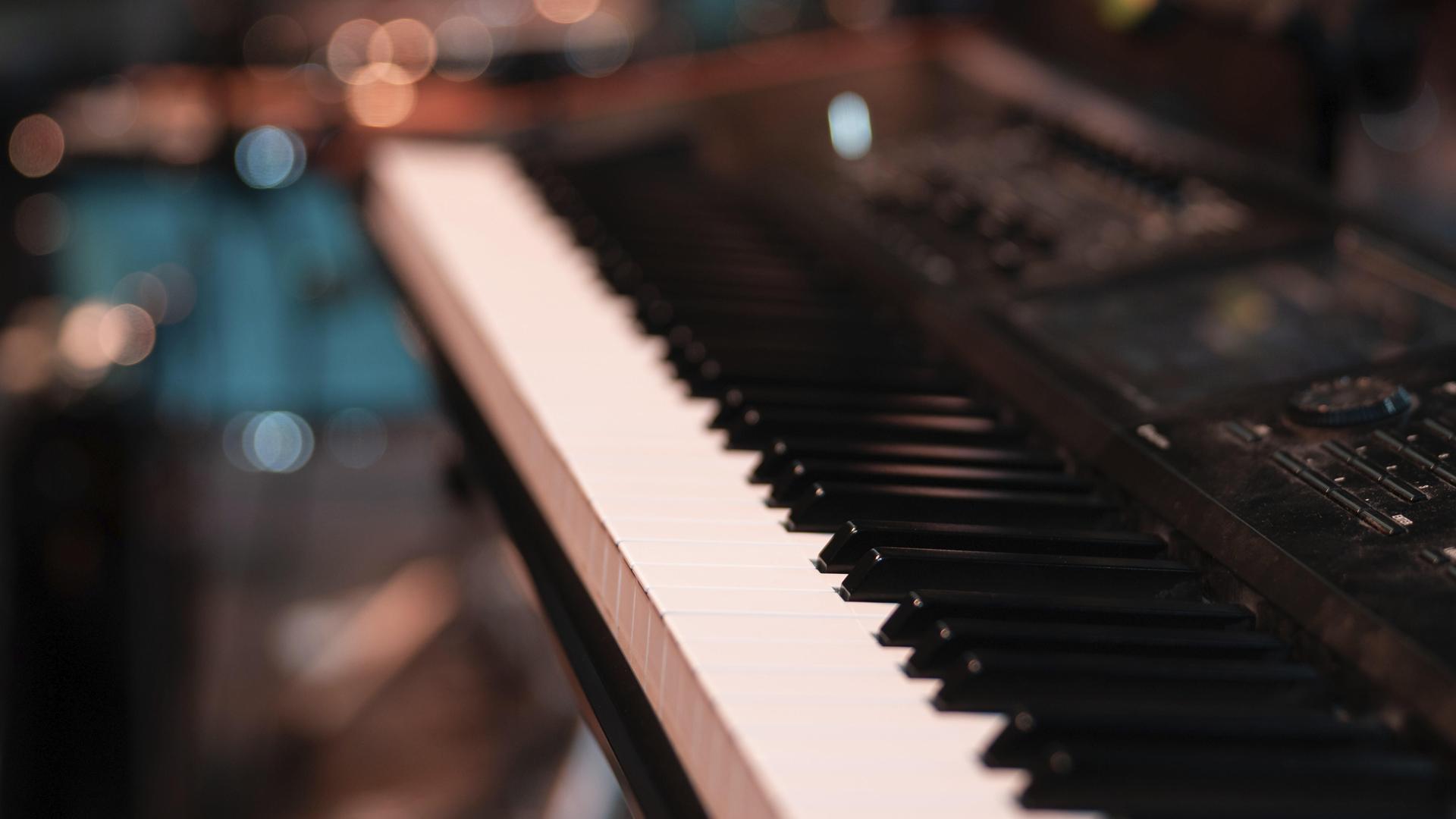 Nahaufnahme von einer Klaviertastatur. Der Hintergrund ist verschwommen