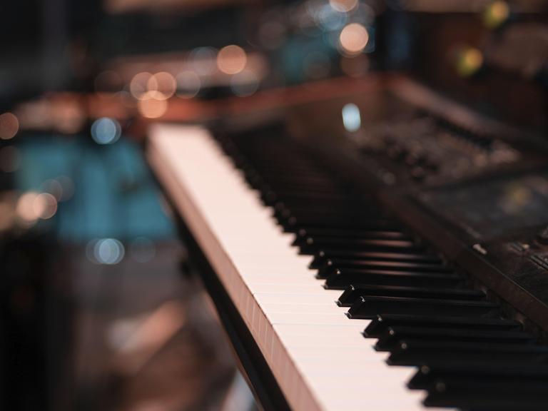 Nahaufnahme von einer Klaviertastatur. Der Hintergrund ist verschwommen