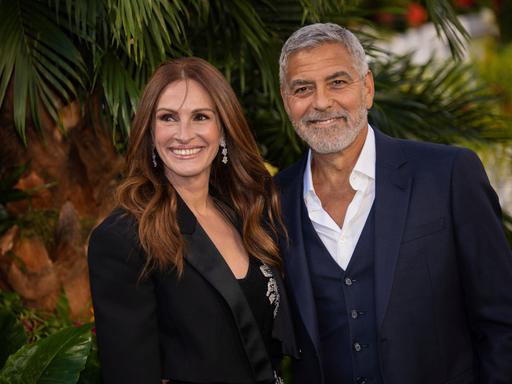 Julia Roberts und George Clooney stehen bei einem Fototermin nebeneinander und lachen.