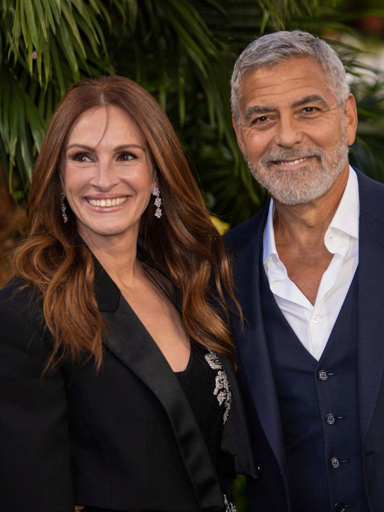 Julia Roberts und George Clooney stehen bei einem Fototermin nebeneinander und lachen.
