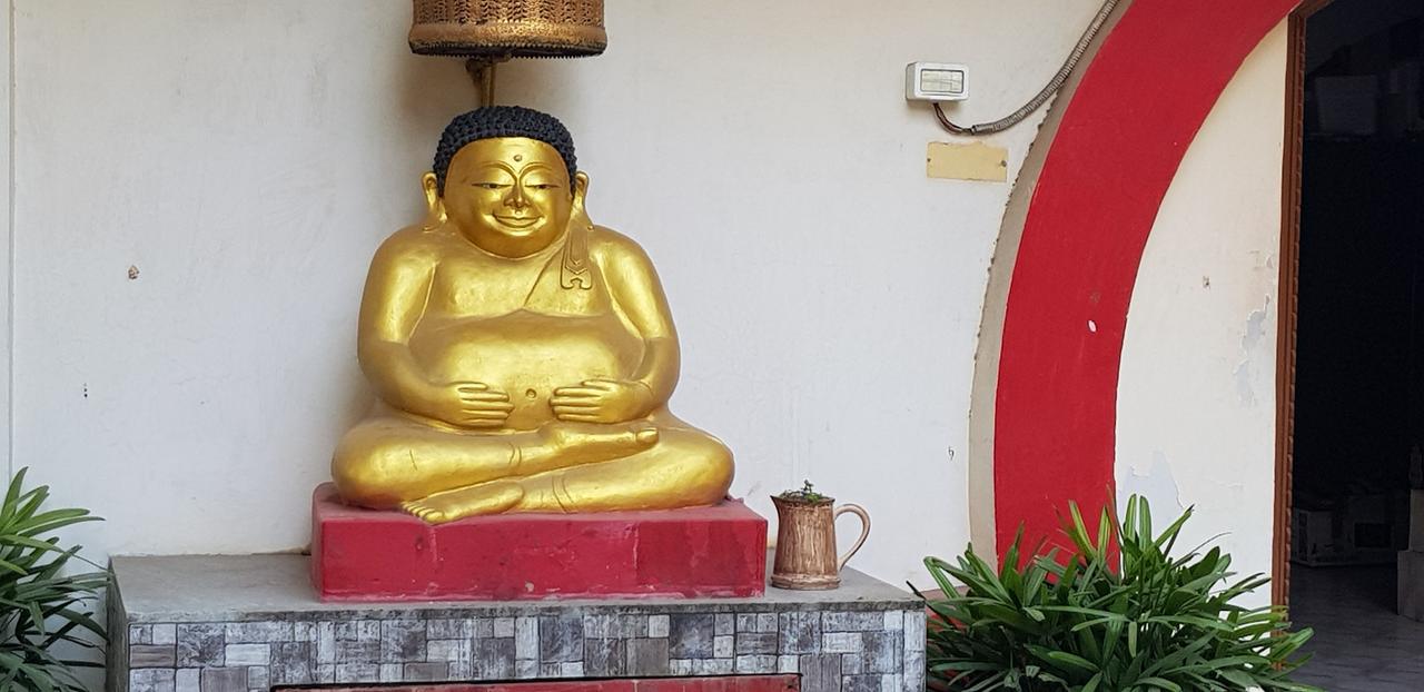 Eingang des buddhistischen Tempels "Bhogal Buddha Vihar" in Delhi mit einer goldenen Buddha-Figur