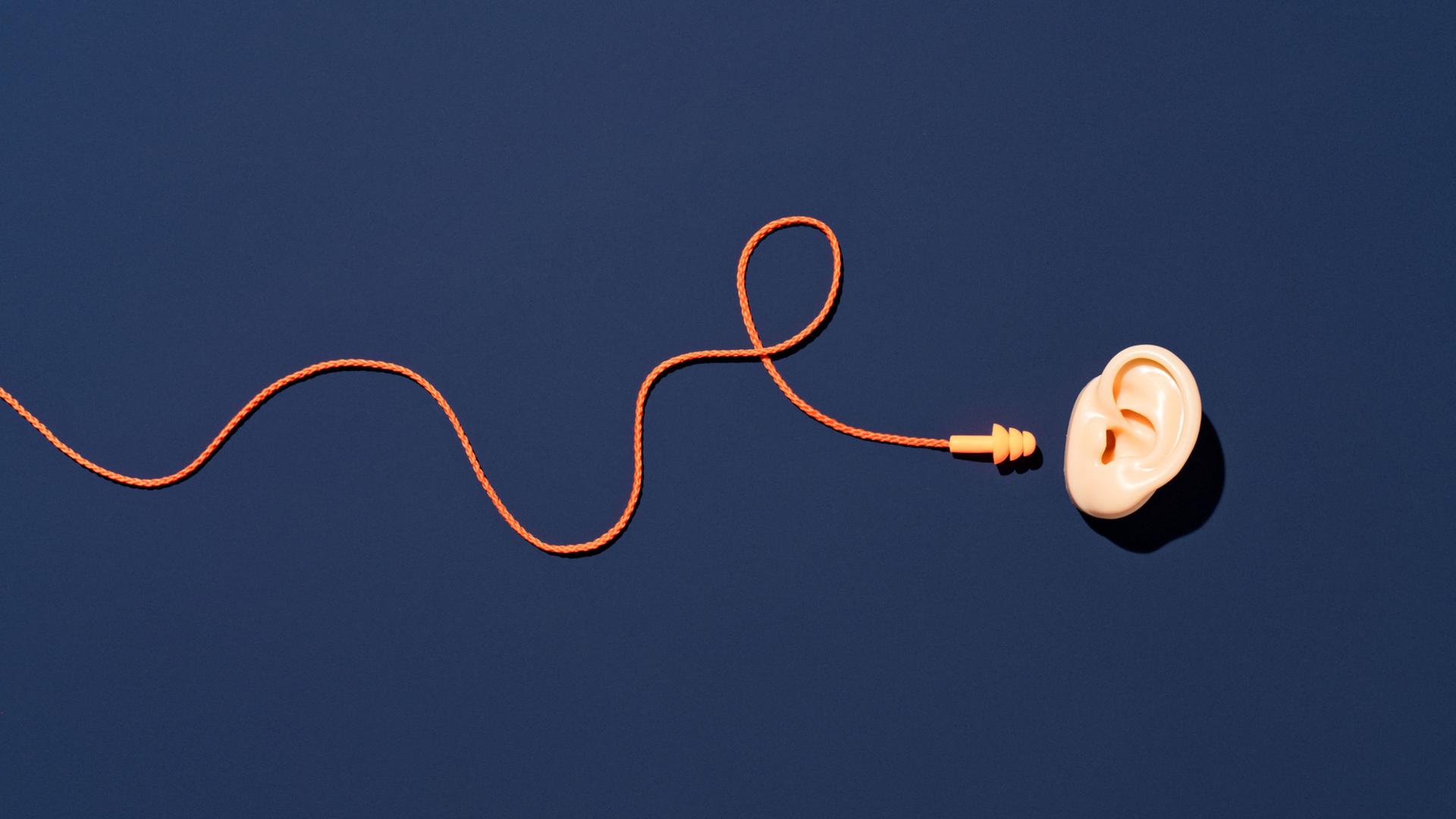 Vor dunkelblauem Hintergrund: Ein Ohr, daneben ein mit dem Ohr nicht verbundenes Kabel mit Stöpsel. Vor dunkelblauem Hintergrund: Ein Ohr, daneben ein mit dem Ohr nicht verbundenes Kabel mit Stöpsel.