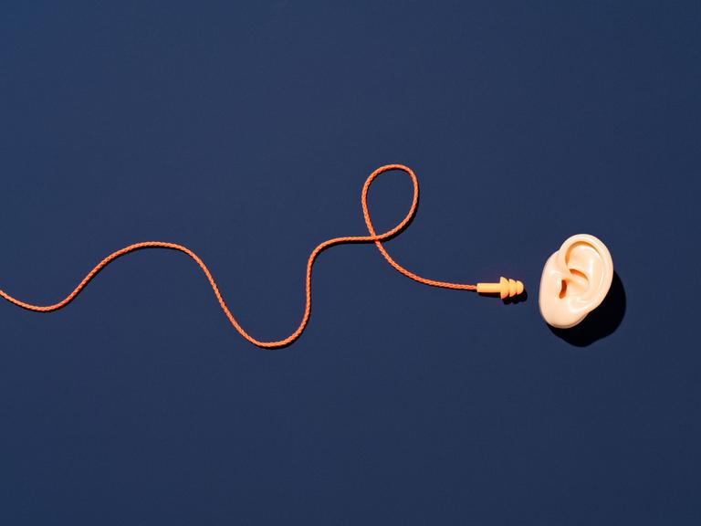 Vor dunkelblauem Hintergrund: Ein Ohr, daneben ein mit dem Ohr nicht verbundenes Kabel mit Stöpsel.