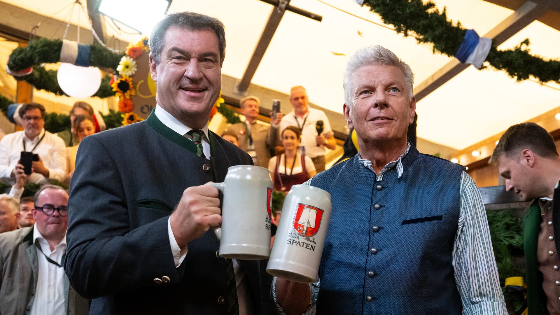 Markus Söder (l, CSU), Ministerpräsident von Bayern und Dieter Reiter (SPD), Oberbürgermeister von München prosten sich beim traditionellen Fassanstich zu.