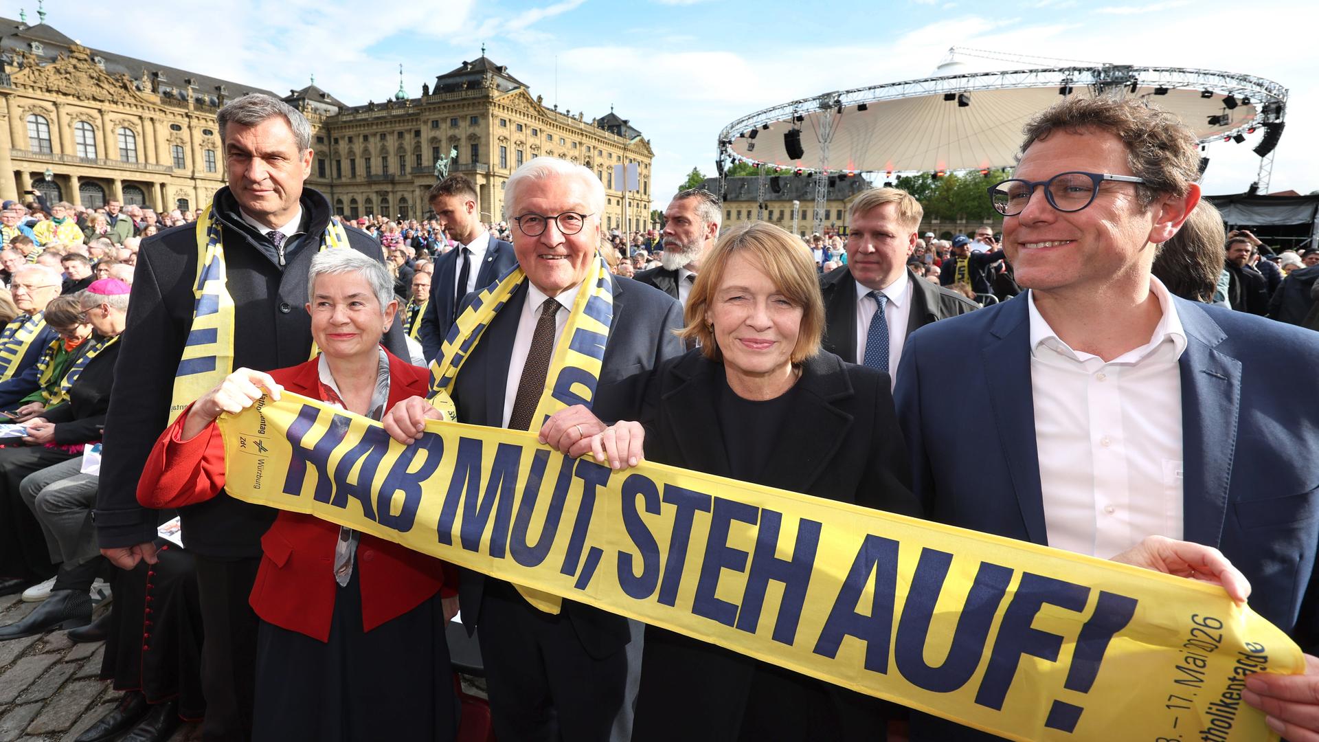 Markus Söder (l-r, CSU), Ministerpräsident von Bayern, Irme Stetter-Karp, Präsidentin der deutschen Katholiken (ZdK), Bundespräsident Frank-Walter Steinmeier, Elke Büdenbender, und Martin Heilig (Bündnis90/die Grünen), Oberbürgermeister von Würzburg, stehen hinter einem Banner mit dem Motto: Hab Mut, steh auf!