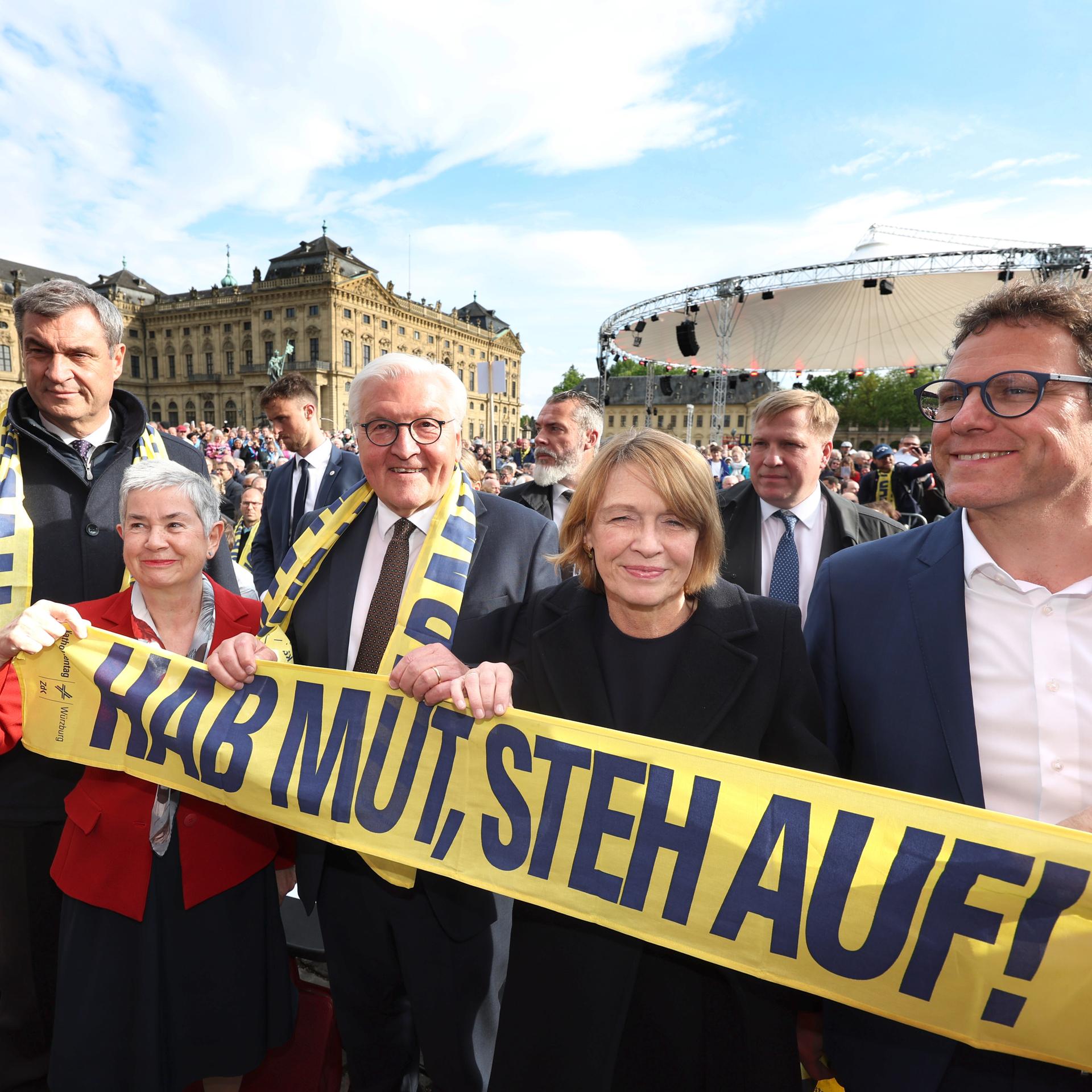 Markus Söder (l-r, CSU), Ministerpräsident von Bayern, Irme Stetter-Karp, Präsidentin der deutschen Katholiken (ZdK), Bundespräsident Frank-Walter Steinmeier, Elke Büdenbender, und Martin Heilig (Bündnis90/die Grünen), Oberbürgermeister von Würzburg, stehen hinter einem Banner mit dem Motto: Hab Mut, steh auf!