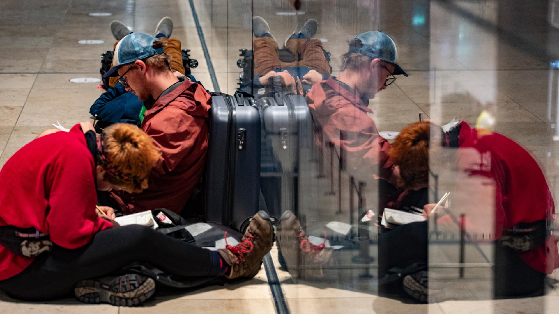 Reisende warten am Flughafen BER auf die Öffnung der Check-in-Schalter. 