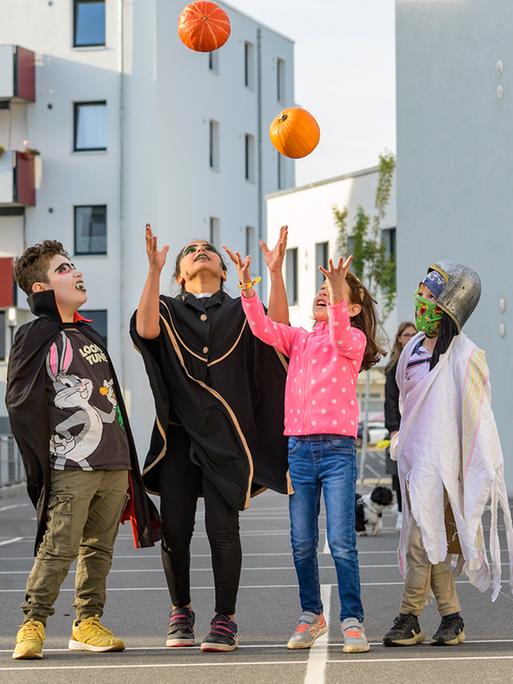 Kinder feiern verkleidet auf der Straße des neun Wohngebiets "ToM Tolerantes Miteinander" Halloween. 
