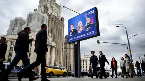 Fußgänger in Moskau gehen am Gebäude des russischen Außenministeriums und an einem Wahlplakat für die Wahl zur russischen Staatsduma (Unterhaus des russischen Parlaments) vorbei. Fußgänger in Moskau gehen am Gebäude des russischen Außenministeriums und an einem Wahlplakat für die Wahl zur russischen Staatsduma (Unterhaus des russischen Parlaments) vorbei.