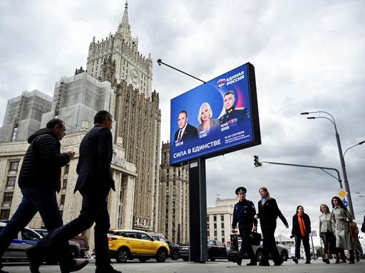 Fußgänger in Moskau gehen am Gebäude des russischen Außenministeriums und an einem Wahlplakat für die Wahl zur russischen Staatsduma (Unterhaus des russischen Parlaments) vorbei. Fußgänger in Moskau gehen am Gebäude des russischen Außenministeriums und an einem Wahlplakat für die Wahl zur russischen Staatsduma (Unterhaus des russischen Parlaments) vorbei.