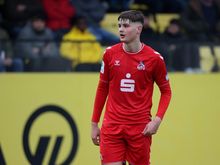 U19-Stürmer Jaka Cuber Potocnik vom 1. FC Köln steht in rotem Trikot des 1. FC Köln auf dem Fußballplatz.