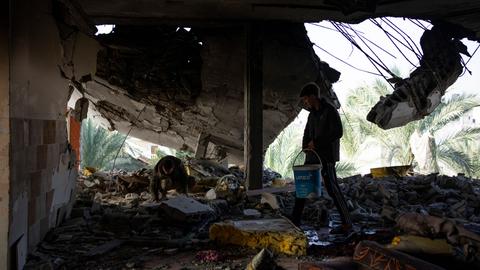 Ein Mann sucht in einem zerstörten Gebäude nach verwertbaren Gegenständen.