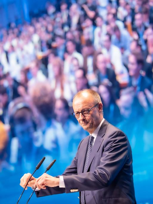 Friedrich Merz steht am Mikrofon, im Hintergrund sieht man zahlreiche Menschen. Friedrich Merz steht am Mikrofon, im Hintergrund sieht man zahlreiche Menschen.