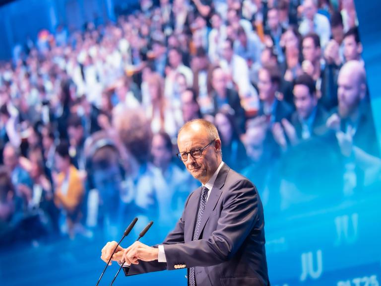 Friedrich Merz steht am Mikrofon, im Hintergrund sieht man zahlreiche Menschen. Friedrich Merz steht am Mikrofon, im Hintergrund sieht man zahlreiche Menschen.