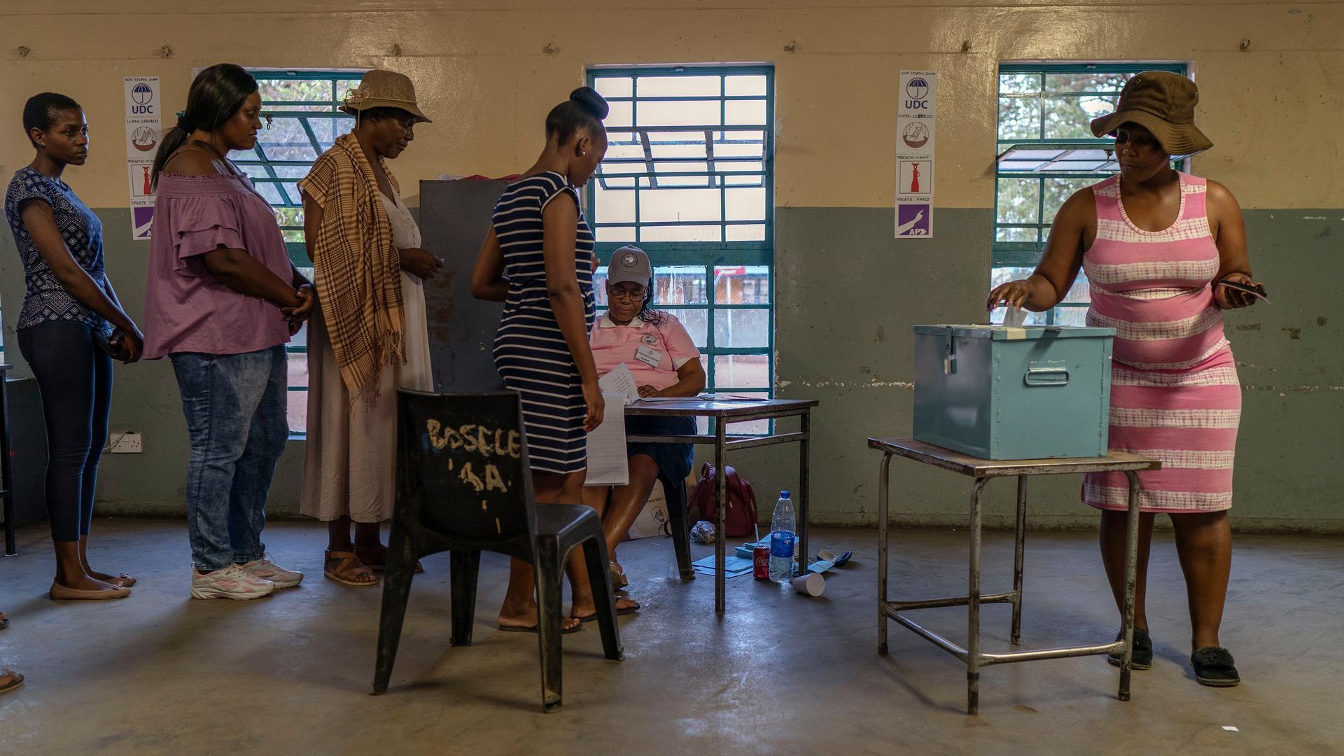 Menschen stehen bei der Parlamentswahl in Botswana 2019 in einer Schlange in einem Wahlbüro, um ihre Stimme in die Urne zu werfen.
