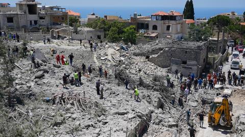 Nach einem israelischen Luftangriff im Südlibanon suchen Rettungskräfte unter Trümmern eines zerstörten Gebäudes nach Opfern. 