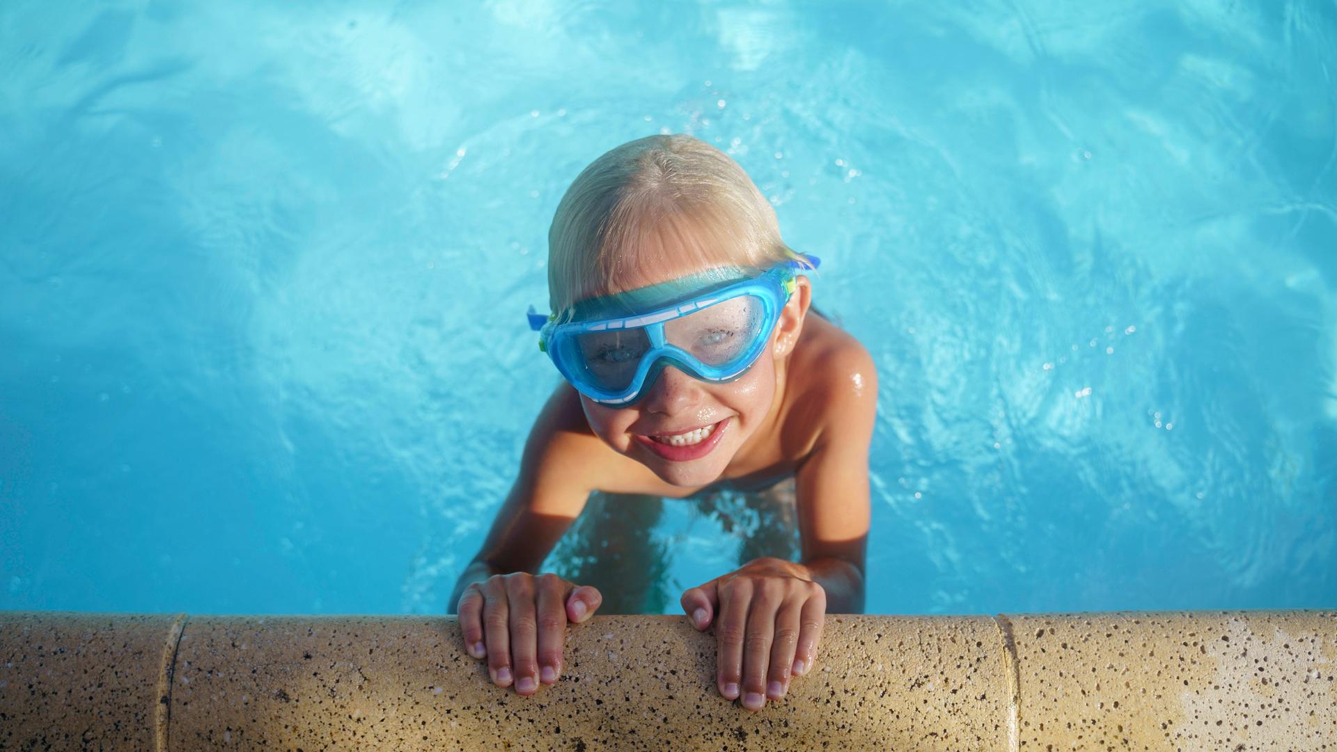 Junge mit Taucherbrille m Schwimmbad Junge mit Taucherbrille m Schwimmbad