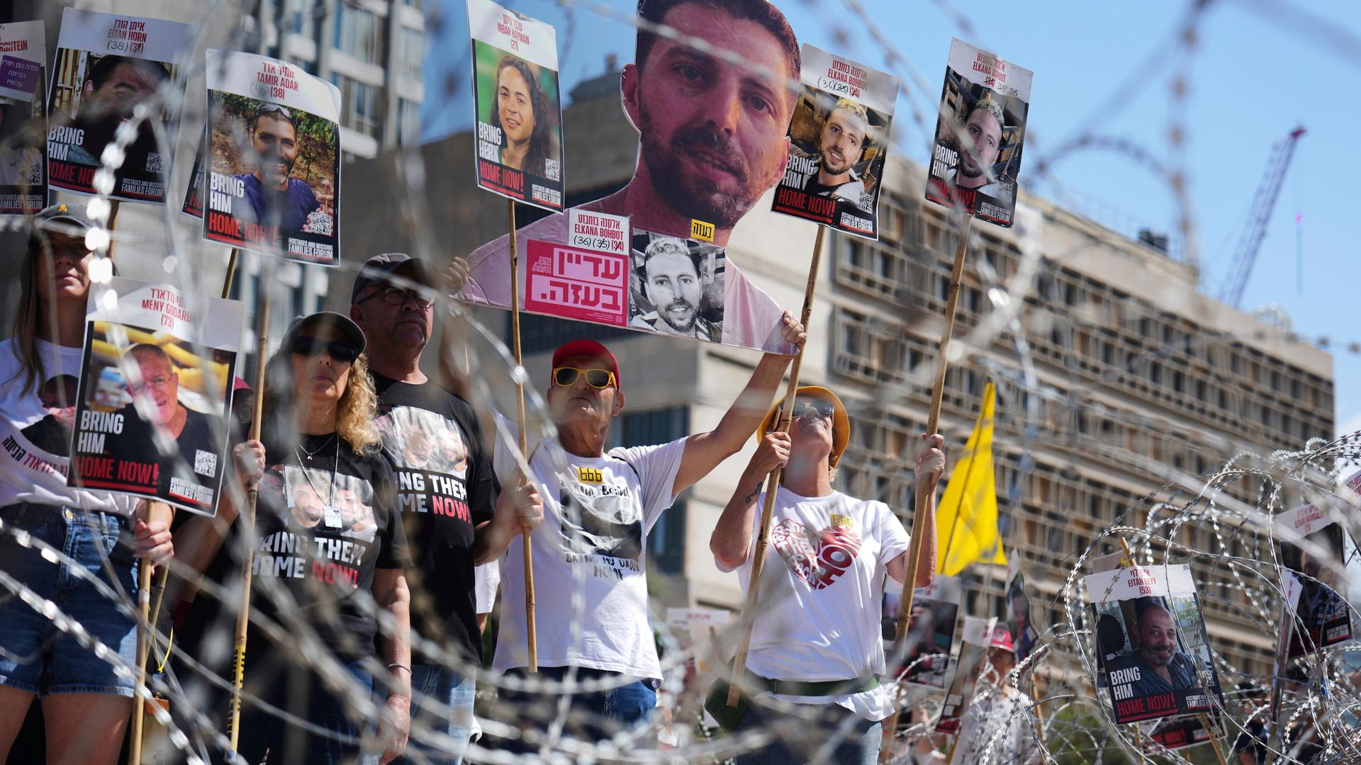 Menschen halten Bilder von Geiseln hoch, die von der Hamas verschleppt wurden. Menschen halten Bilder von Geiseln hoch, die von der Hamas verschleppt wurden.