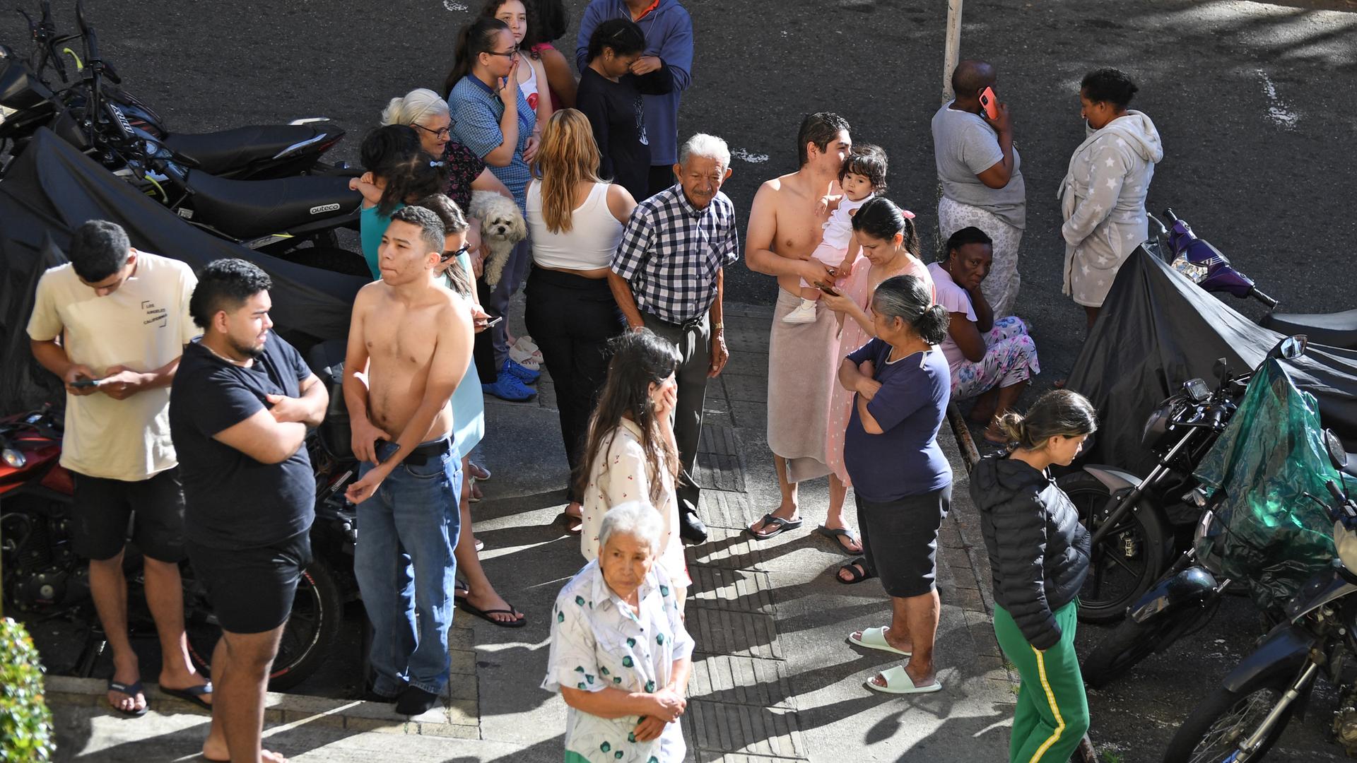Menschen, die evakuiert wurden, stehen nach einem Erdbeben in Medellin in Kolumbien auf der Straße.