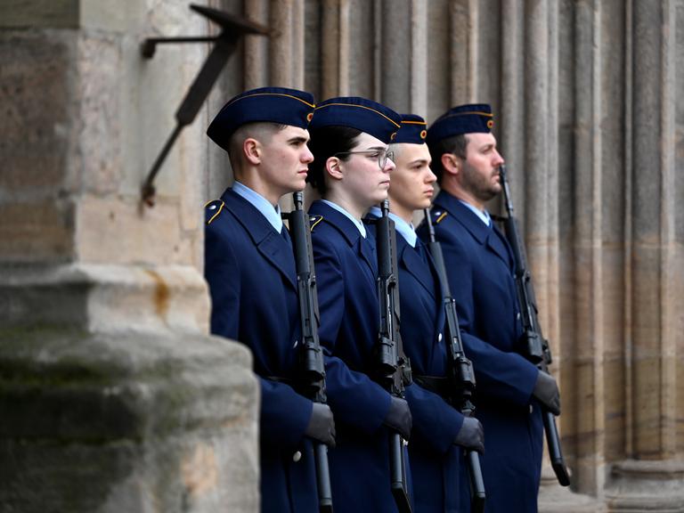 Rekruten und Rekrutinnen der Bundeswehr stehen mit einem Gewehr in der Hand bei einem öffentlichen Gelöbnis der Bundeswehr in Nürnberg stramm.