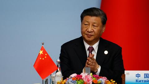 Der chinesische Präsident Xi-Jinping sitzt während des China-Zentralasien-Gipfels an einem Tisch hinter einem Mikrofon. Auf dem Tisch steht eine chinesische Flagge.