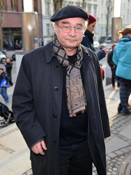 Martin Seifert schaut in die Kamera. Er trägt eine schwarze Baskenmütze und einen Schal mit braunem Paisleymuster.