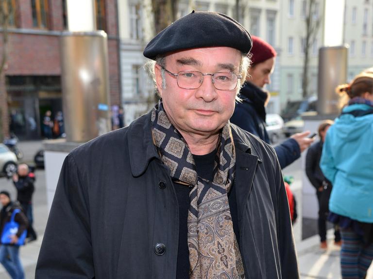 Martin Seifert schaut in die Kamera. Er trägt eine schwarze Baskenmütze und einen Schal mit braunem Paisleymuster.