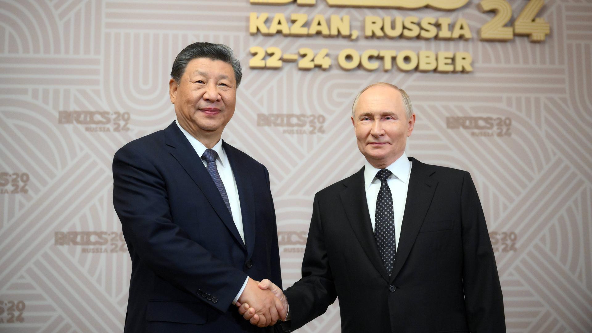 Der Präsident von dem Land Russland heißt Wladimir Putin (auf der rechten Seite von dem Foto). Er begrüßt in der Stadt Kasan den Präsidenten von China, Xi Jinping.