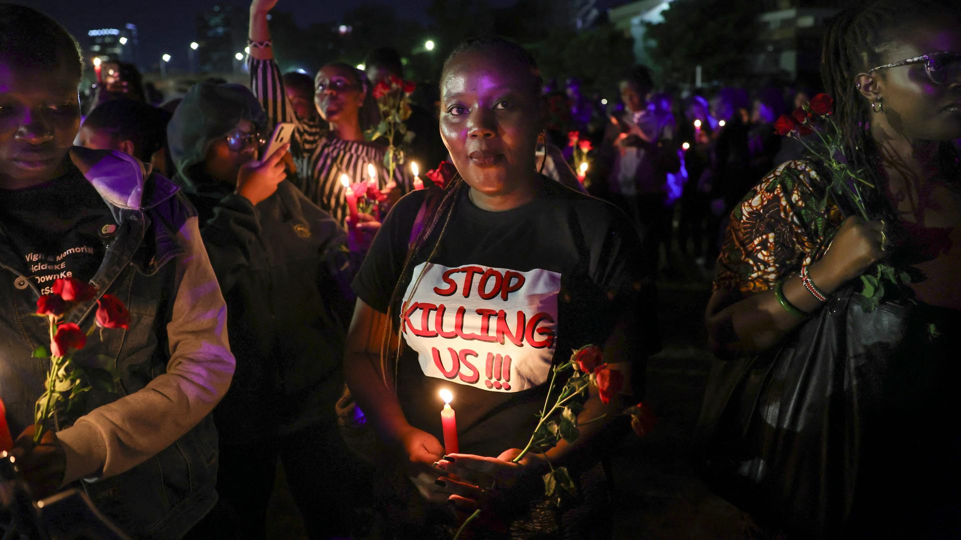 Aktivistinnen strecken Kerzen und rote Rosen in die Höhe, eine Mahnwache zum Gedenken an junge Frauen, die bei geschlechtsspezifischer Gewalt ums Leben gekommen sind. Nairobi, 14. Februar 2024.